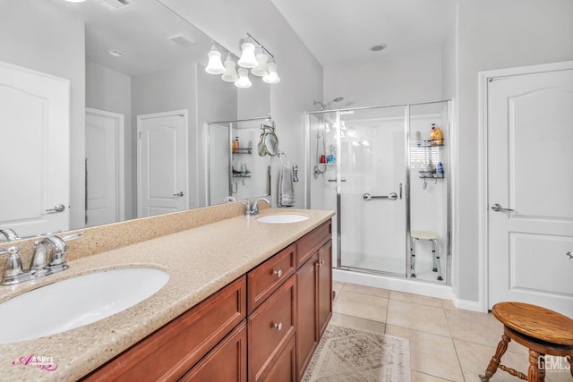 bathroom with tile patterned flooring, a stall shower, and a sink