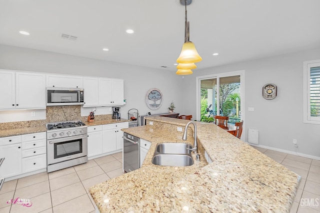 kitchen with light tile patterned floors, visible vents, a center island with sink, a sink, and stainless steel appliances