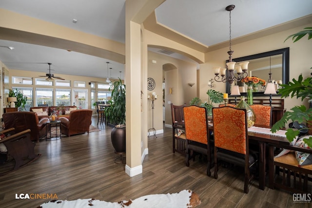 dining room with dark hardwood / wood-style flooring and ceiling fan with notable chandelier