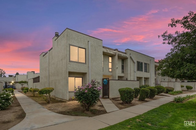 view of front of property featuring stucco siding and fence