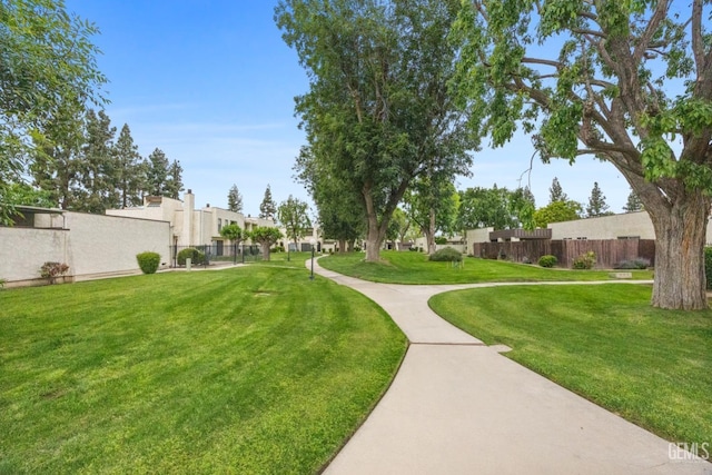 view of community featuring fence and a lawn