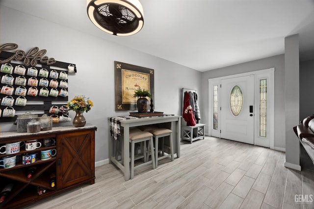 foyer entrance with baseboards and wood finished floors