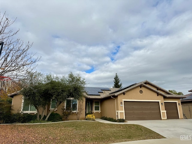 ranch-style house featuring a front yard, solar panels, and a garage