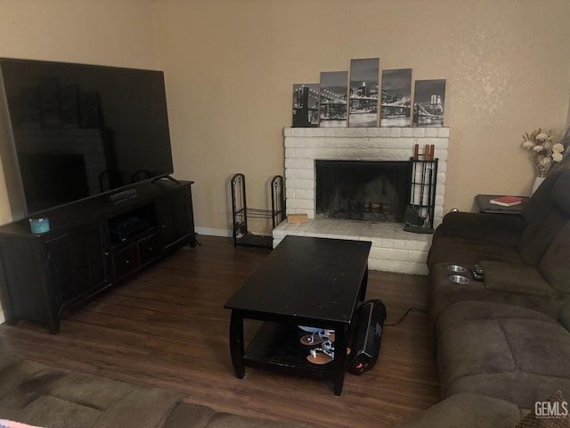 living area with a fireplace, dark wood finished floors, and baseboards