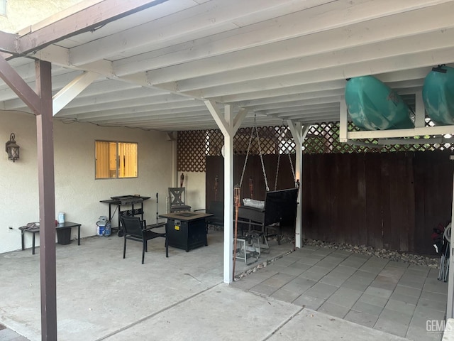 view of patio with an outdoor fire pit and fence