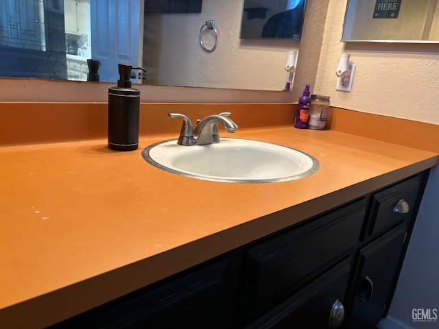 bathroom featuring a textured wall and vanity