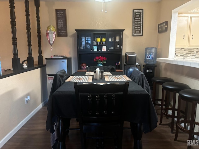 dining space with dark wood-style flooring and baseboards