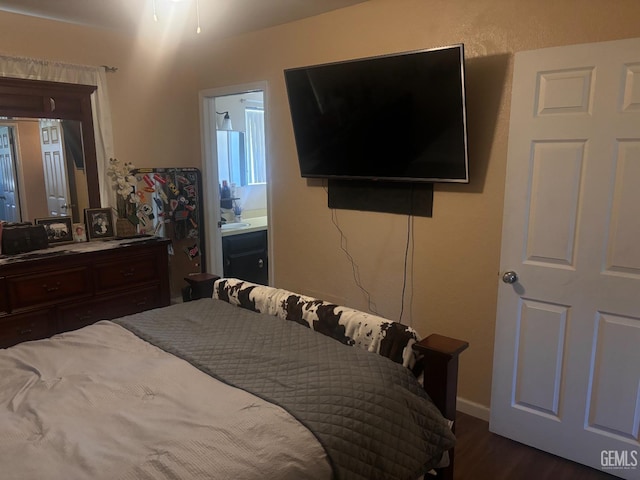 bedroom featuring dark wood-style flooring and connected bathroom