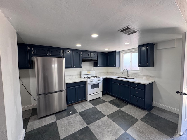 2912 Wilson Rd, Bakersfield, CA 93304 - kitchen with white gas range, freestanding refrigerator, dark floors, a textured ceiling, and blue cabinets