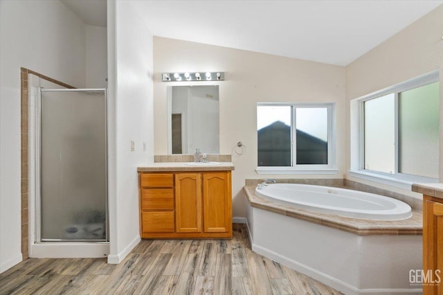22940 Fast Ct, Bakersfield, CA 93314 - bathroom featuring vanity, a stall shower, wood finished floors, a bath, and vaulted ceiling