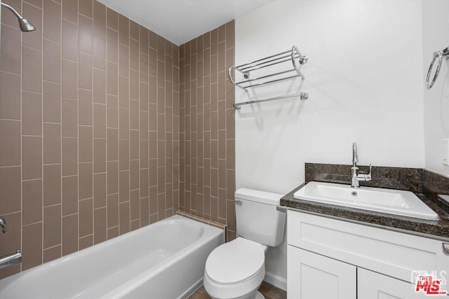 full bathroom with tiled shower / bath, vanity, and toilet