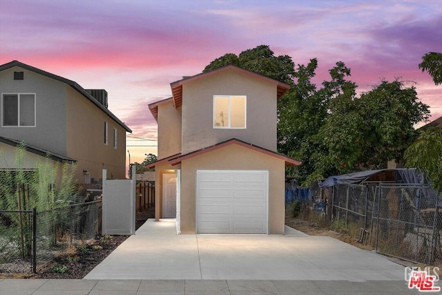 view of property featuring a garage and central AC