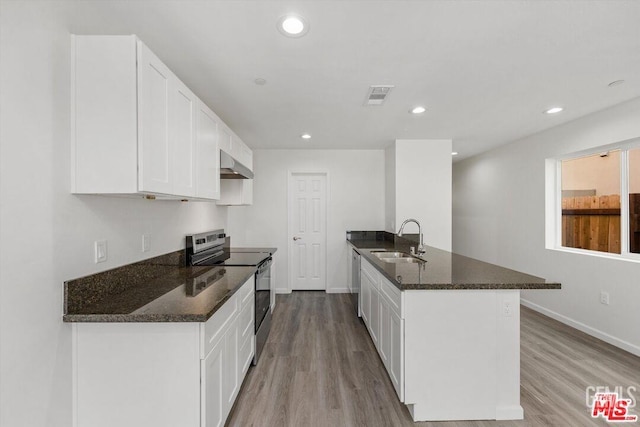 kitchen featuring appliances with stainless steel finishes, sink, dark stone countertops, and white cabinets