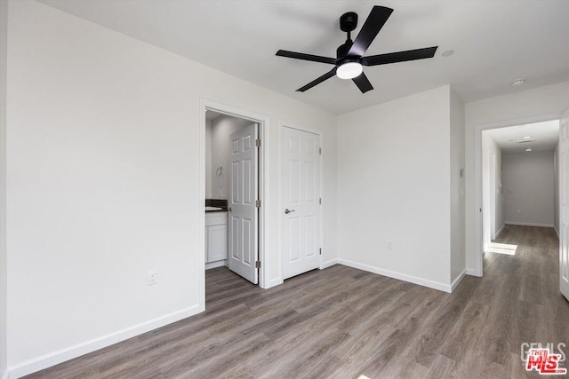 spare room featuring dark wood-type flooring and ceiling fan