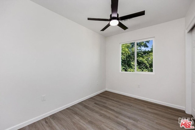 spare room featuring dark wood-type flooring and ceiling fan