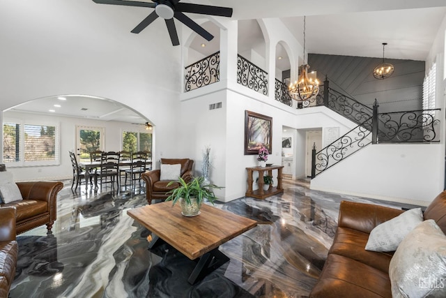 living room with visible vents, stairs, ceiling fan with notable chandelier, arched walkways, and marble finish floor