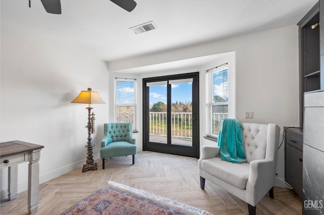 sitting room featuring visible vents, baseboards, and a ceiling fan