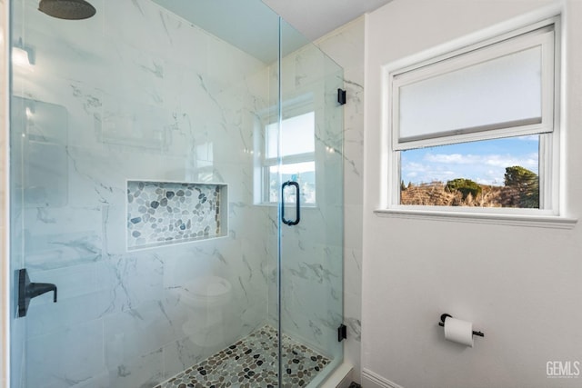 bathroom featuring a marble finish shower