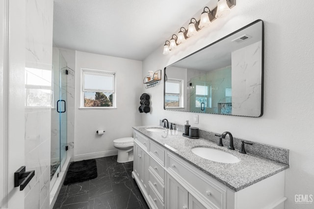 bathroom with a sink, a marble finish shower, toilet, and marble finish floor