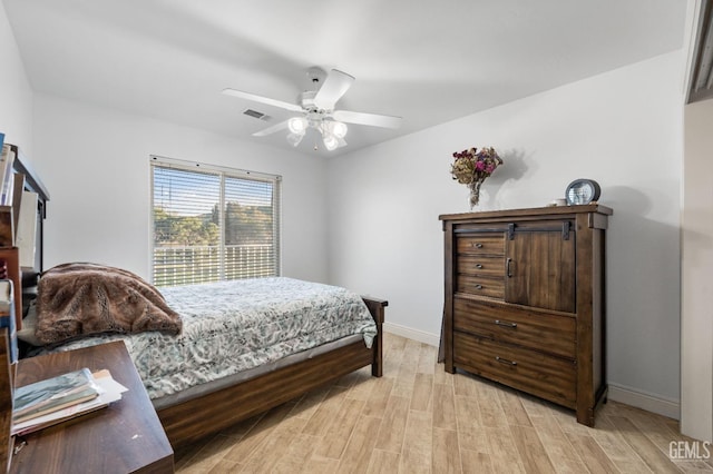 bedroom with visible vents, a ceiling fan, light wood-type flooring, and baseboards