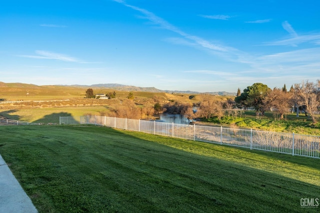 view of yard with a rural view, a mountain view, and fence