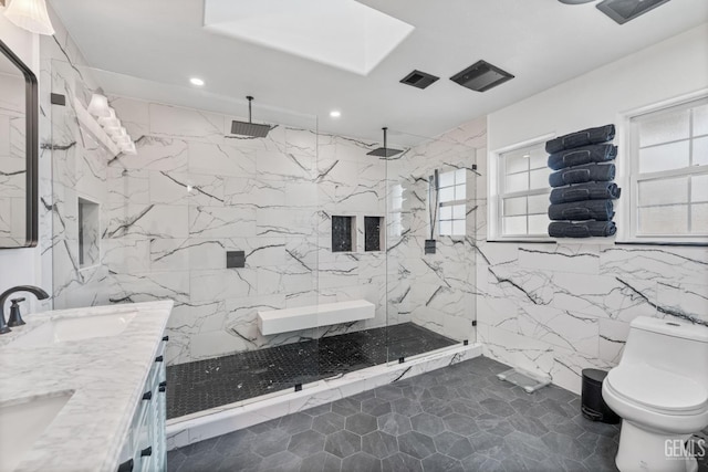 full bath with a marble finish shower, double vanity, a sink, tile walls, and toilet