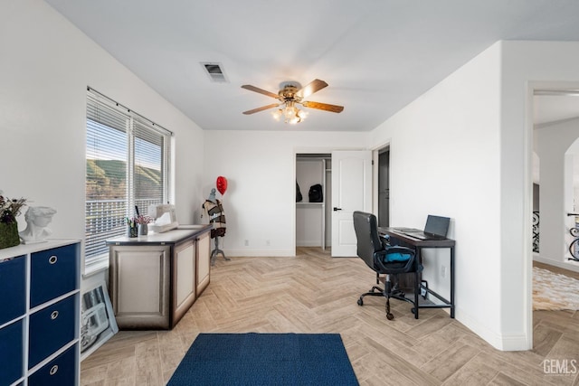 office space featuring visible vents, baseboards, arched walkways, and ceiling fan