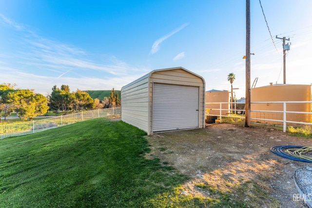 garage featuring a storage unit and fence