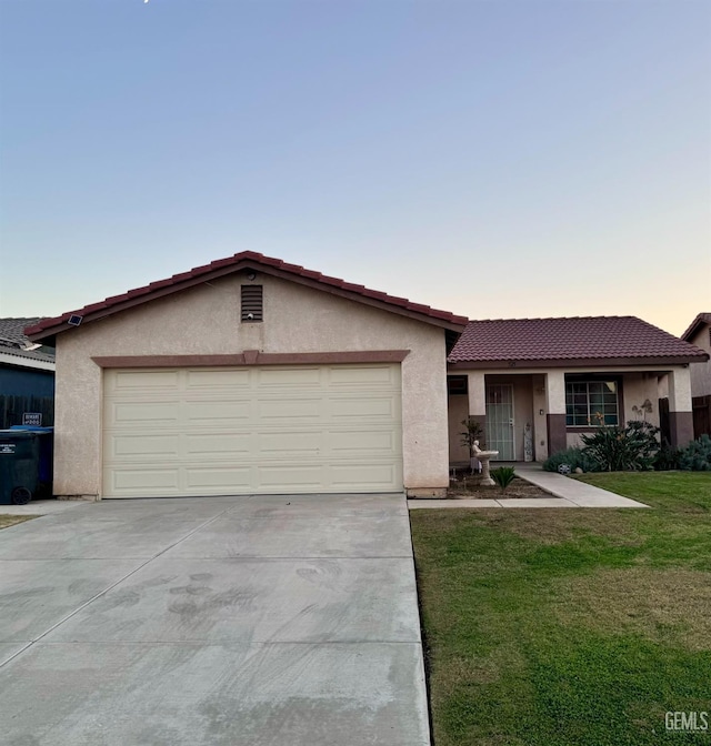 ranch-style home featuring a yard and a garage