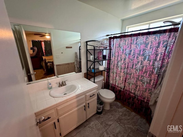 full bathroom featuring shower / tub combo, vanity, toilet, and wood walls