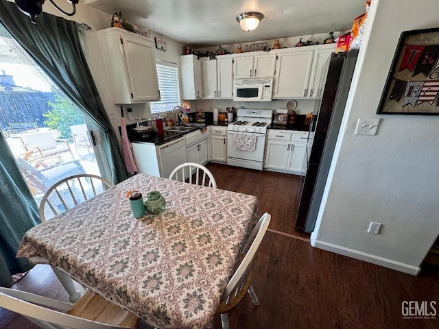 kitchen with sink, white cabinets, dark hardwood / wood-style floors, and white appliances