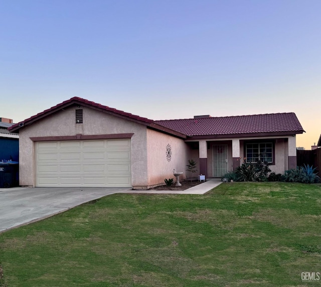 ranch-style home featuring a yard and a garage