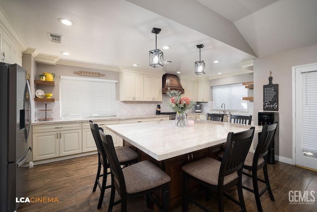10005 Valley Forest Ct, Bakersfield, CA 93311 - kitchen featuring premium range hood, open shelves, visible vents, a kitchen bar, and stainless steel fridge with ice dispenser