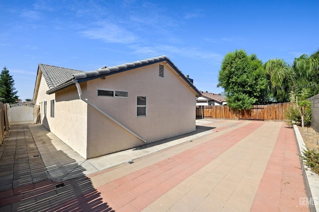 3410 Kimmie Rachelle Ct, Bakersfield, CA 93313 - view of home's exterior with a patio area, a fenced backyard, stucco siding, and a tile roof
