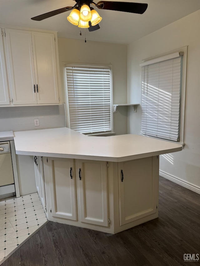 kitchen with dark wood-type flooring, white cabinets, white dishwasher, ceiling fan, and kitchen peninsula