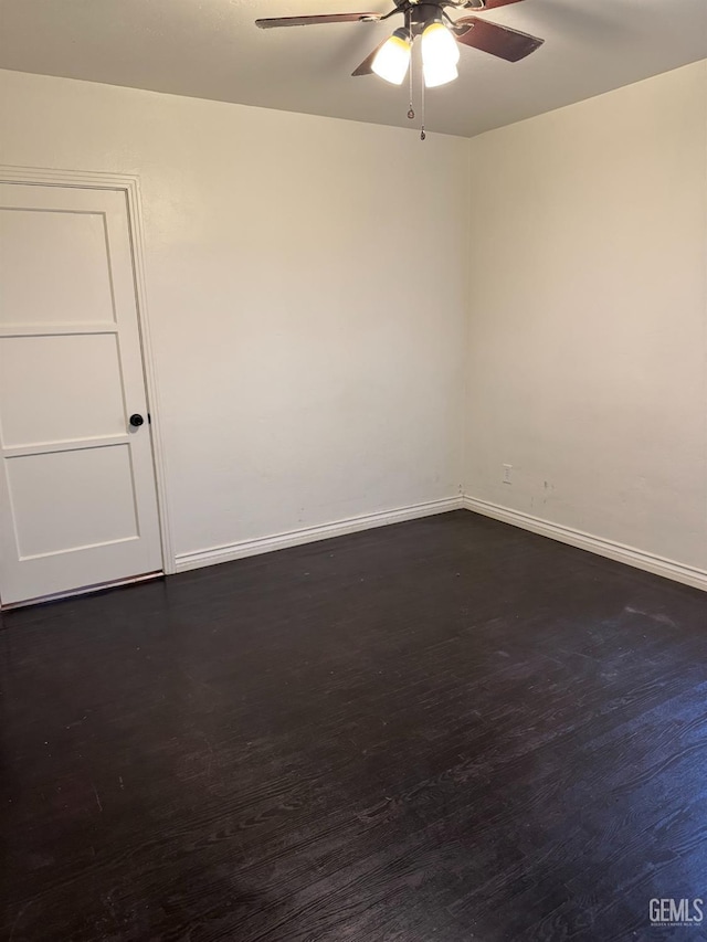 empty room with ceiling fan and dark hardwood / wood-style flooring