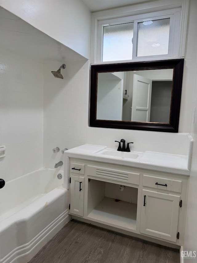 bathroom featuring hardwood / wood-style flooring, vanity, and tiled shower / bath combo