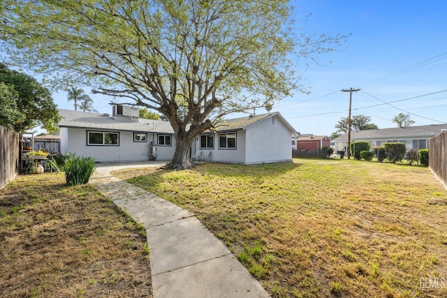 view of front of house with a fenced backyard, a front yard, and a patio area