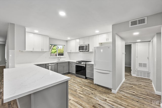 kitchen with a sink, visible vents, stainless steel appliances, and gray cabinets