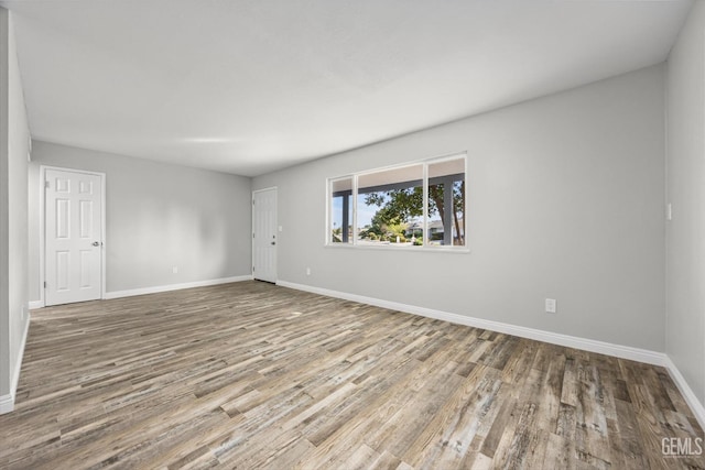 empty room with baseboards and wood finished floors