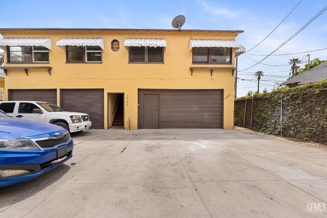 1940 S La Salle Ave, Los Angeles, CA 90018 - view of front of home with stucco siding, a garage, driveway, and fence