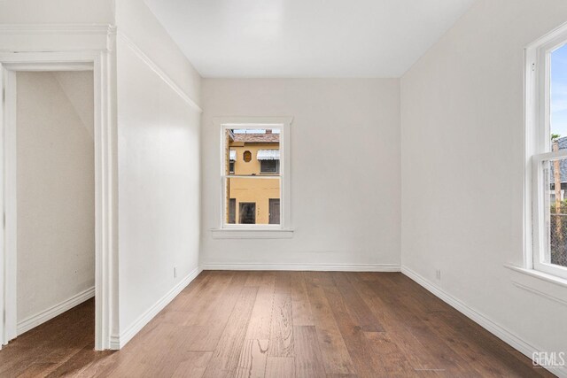 1940 S La Salle Ave, Los Angeles, CA 90018 - unfurnished room featuring wood finished floors, plenty of natural light, and baseboards