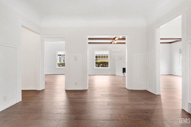 1940 S La Salle Ave, Los Angeles, CA 90018 - unfurnished room featuring dark wood-style floors, beamed ceiling, and a decorative wall