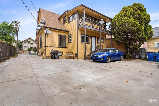 1940 S La Salle Ave, Los Angeles, CA 90018 - rear view of property featuring a balcony, fence, and roof with shingles