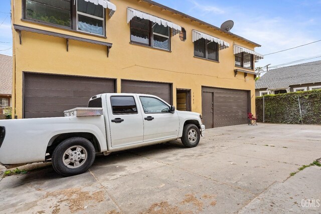 1940 S La Salle Ave, Los Angeles, CA 90018 - view of front of home featuring an attached garage, stucco siding, driveway, and fence