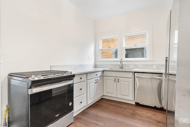 1940 S La Salle Ave, Los Angeles, CA 90018 - kitchen with stainless steel appliances, a sink, white cabinetry, dark wood-style floors, and light stone countertops