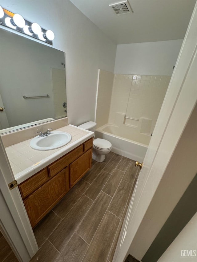 full bath with wood tiled floor, vanity, visible vents, and toilet