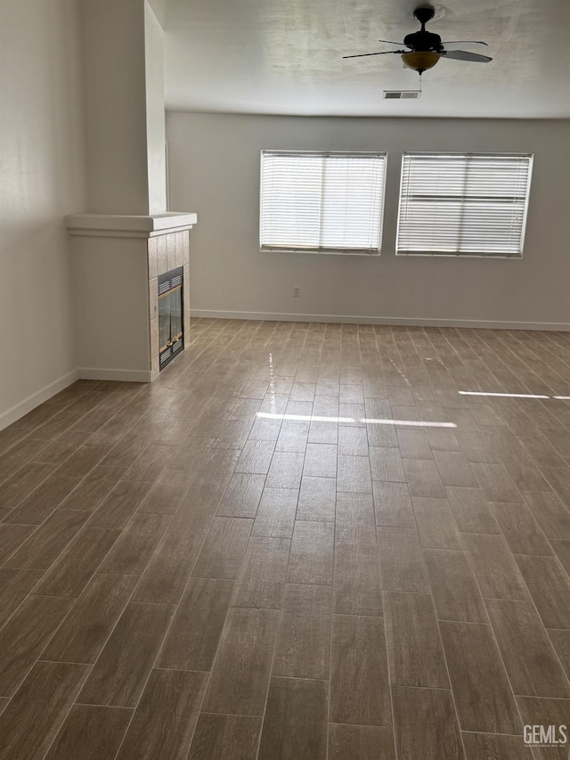 unfurnished living room featuring visible vents, ceiling fan, and dark wood finished floors