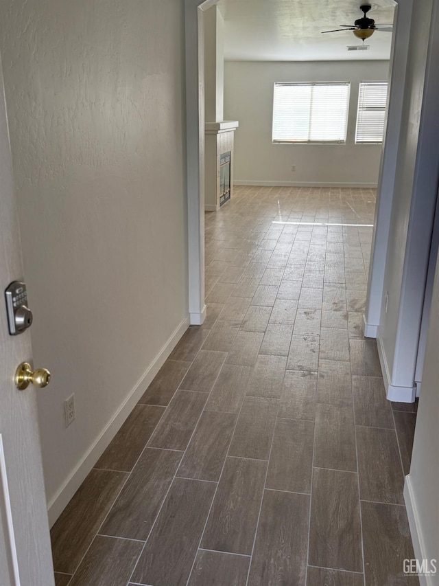 corridor with baseboards and wood finish floors