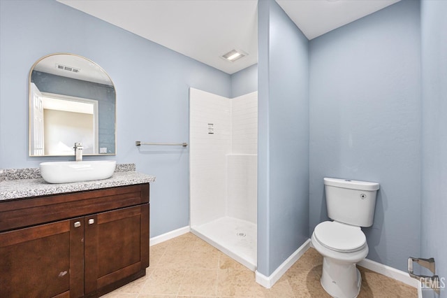 bathroom featuring toilet, vanity, visible vents, baseboards, and a tile shower